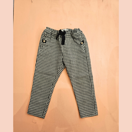 pantalon vichy noir et blanc, noeud noir, poches fermées par un bouton couleur bois. Marque ZARA